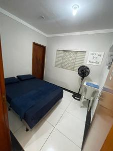 a bedroom with a bed and a desk and a fan at Suítes Canaã in Uberlândia