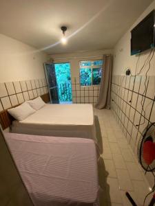 a room with two beds and a television in it at Hotel Cascata in Tianguá +8 photos