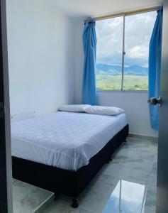 a bedroom with a bed and a large window at Apartamento Conjunto Altos de Laureles in Melgar