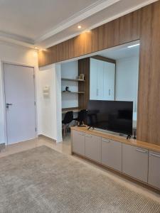 a living room with a large flat screen tv at Studio 68 Completo com Garagem - Araçatuba-SP in Araçatuba