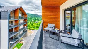 a balcony with chairs and a table on a building at Apartament Loft- IzerSKI Resort in Świeradów-Zdrój