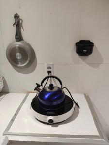 a blue tea kettle sitting on top of a stove at kitnet in Petrolina
