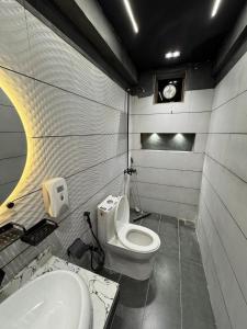 a bathroom with a toilet and a sink at Double Delight-Two Single Beds, Private Entrance Available On Sharing Also in Karachi
