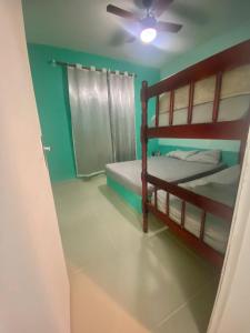 une chambre avec deux lits superposés et un ventilateur de plafond dans l'établissement Apartamento da Prainha, à Arraial do Cabo