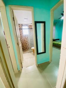 une salle de bain avec des murs bleus et un miroir et des toilettes dans l'établissement Apartamento da Prainha, à Arraial do Cabo
