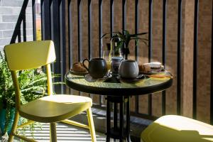 a table with tea cups and bread on a balcony at Estudio OXYGEN 34 Curitiba in Curitiba