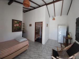 a bedroom with a bed and a chair in a room at Pousada Vila Dendê in Trancoso +62 photos