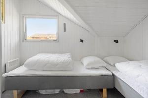 two beds in a small room with a window at M365-Gedser-Lollandsvej-9 in Gedser