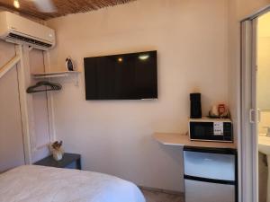 a room with a tv on the wall with a bed at Bella Noni B&B in Aguadilla