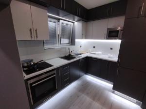 a kitchen with black cabinets and white counters at При митака in Pernik +4 photos