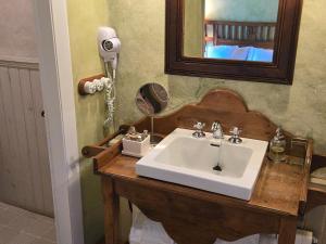 a bathroom with a white sink and a mirror at Casa do Castelo de Andrade in Puentedeume +61 photos