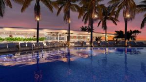 a swimming pool with palm trees and a building at Omni Fort Lauderdale Hotel in Fort Lauderdale