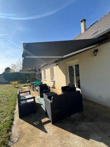 a patio with black chairs and a patio umbrella at Le Pavillon - Ideal CNPE et découverte de la Touraine in Chinon