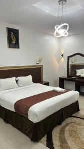 a bedroom with a large bed and a desk at Seasons Apartments in Jazan +30 photos