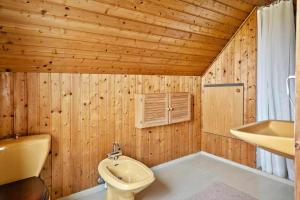 ein Holzbadezimmer mit einem WC und einem Waschbecken in der Unterkunft M374 Gedser - Birkevej 3 in Gedser + 14 Fotos