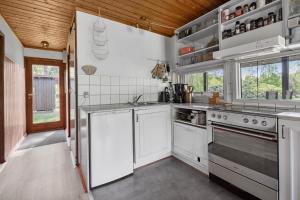 eine Küche mit weißen Geräten und einer Holzdecke in der Unterkunft L38 Rødby - Lærkevænget 10 in Rødby + 13 Fotos