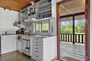 eine Küche mit weißen Geräten und einem großen Fenster in der Unterkunft L38 Rødby - Lærkevænget 10 in Rødby