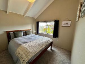 a bedroom with a bed and a window at Spacious Family Home in Te Anau in Te Anau +6 photos