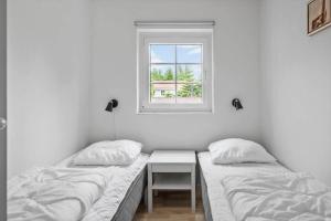 two beds in a room with a window at M386-Vaeggerlose-Skarntydevej-27 in Marielyst +13 photos