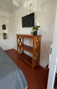 a room with a table with a tv and a table with a plant at CANTINHO da ARMAÇAO in Búzios +41 photos