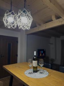 a bottle of wine sitting on a table with two glasses at Vikendica Diva in Varvara +36 photos