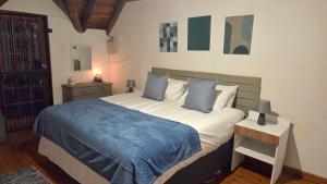 a bedroom with a large bed with a blue blanket at Dika Dika Den in Phalaborwa