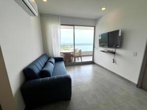 a living room with a couch and a television at Apartamento familiar en Santa Marta con vista al mar y la Sierra in Santa Marta