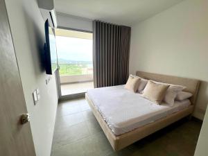 a bedroom with a bed with a large window at Apartamento familiar en Santa Marta con vista al mar y la Sierra in Santa Marta +16 photos