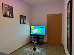 a living room with a tv and a glass table at Käthe-Kollwitz Straße 54, F1 in Altenburg