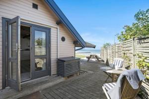 eine Terrasse mit einem Grill, einem Tisch und Stühlen in der Unterkunft SL261 Korsør - Svenstrup Strandvej 109 in Korsør