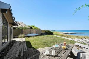ein Picknicktisch mit einer Flasche Wein, die auf einem Rasen steht in der Unterkunft SL261 Korsør - Svenstrup Strandvej 109 in Korsør + 14 Fotos