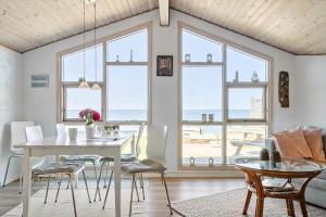 ein Esszimmer mit Tisch und Stühlen und Fenstern in der Unterkunft SL261 Korsør - Svenstrup Strandvej 109 in Korsør