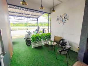 Ban KohongにあるinSmile Houseのテーブルと椅子が置かれたガレージに駐車されたスクーター