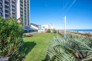 a park next to the beach with buildings and palm trees at Pets welcome,direct oceanfront, poolside,1 bedroom in Myrtle Beach