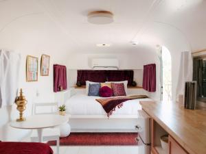 a bedroom with a white bed with red pillows at Acres Landing in Desert Hot Springs