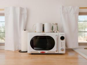 a white microwave sitting on top of a wooden floor at Acres Landing in Desert Hot Springs