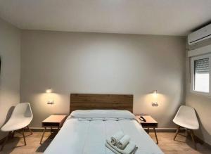 a bedroom with a bed and two tables and chairs at Hostal Pompeya Merida in Mérida +9 photos
