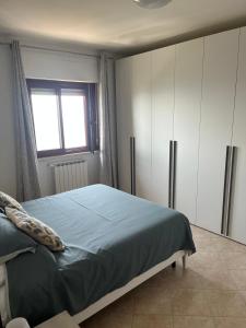 ein Schlafzimmer mit einem Bett und einem Fenster in der Unterkunft Ninfa in Norma