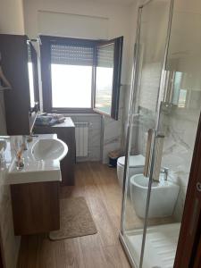 ein Badezimmer mit zwei Waschbecken, Dusche und Toilette in der Unterkunft Ninfa in Norma + 9 Fotos