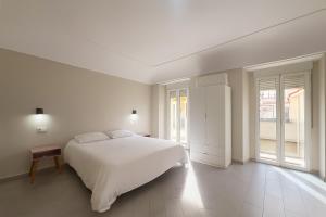 梅里达Hostal Pompeya Merida的白色的卧室设有白色的床和窗户。