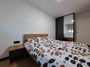 a bedroom with a large bed and a large mirror at Alpine Noir 2 in Bjelašnica