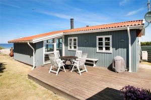 a blue house with a table and chairs on a deck at SL190-Korsor-Svenstrup-Strandvej-103 in Korsør