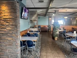 a dining room with tables and chairs and a brick wall at Big Horn motor Inn in Grande Cache