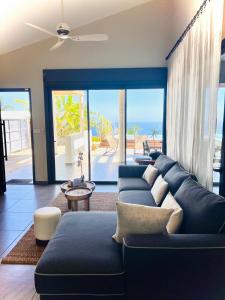 - un salon avec un canapé bleu et une vue sur l'océan dans l'établissement Comme un bateau sur l'océan, à Saint-Leu