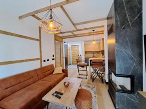 ein Wohnzimmer mit Sofa und Tisch in der Unterkunft Alpine Noir in Bjelašnica