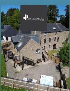 a large brick building with a table and benches at CORN FLOUR LODGE at PITKERRO MILL, 3 double bedrooms with TVs, 1 en-suite, 2 further bathrooms, fully equipped kitchen, large family dining area, FREE parking and WiFi, HOT TUB, private garden, short mid and longterm stays available with HONEYCOMB HOSTS in Dundee