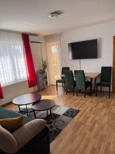 a living room with a couch and a table and chairs at Beauty Room Apartman in Prnjavor