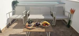 two chairs and a table with a bowl of fruit at Alcalá Playa Terraza in Rota