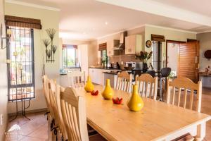 a kitchen with a wooden table with yellow vases on it at Aleah, Cathkin Estates by Euphoric Leisure in Champagne Valley