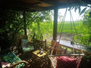 a porch with chairs and a table and a swing at Sweet Treehouse in Westbeemster +23 photos